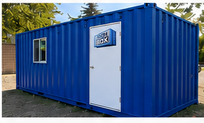 A blue Iron Box shipping container modified with a white personnel door and window, set up as a workshop or storage building